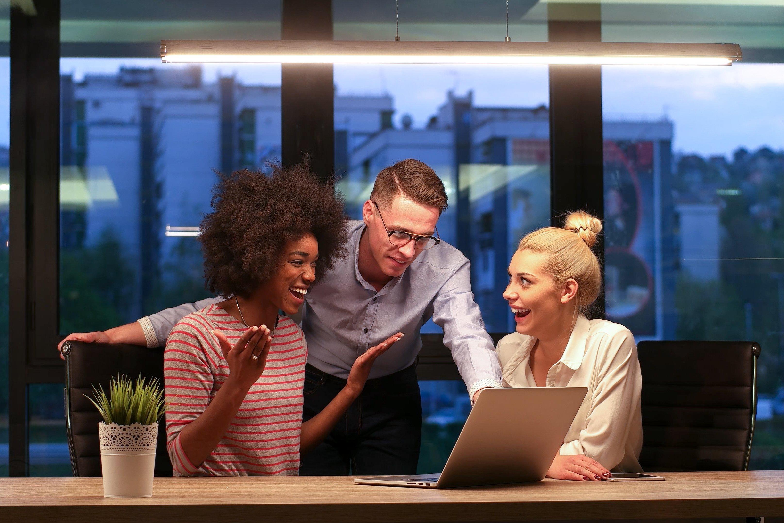 coworkers looking in a laptop